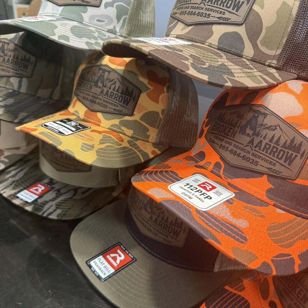 Camo trucker hats with custom engraved leather patches for Broken Arrow Drone and Search Services