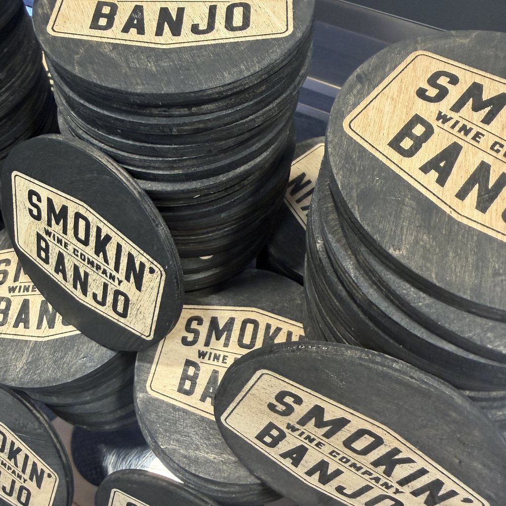 Bulk run of engraved slate coasters branded for Smokin' Banjo Wine Company