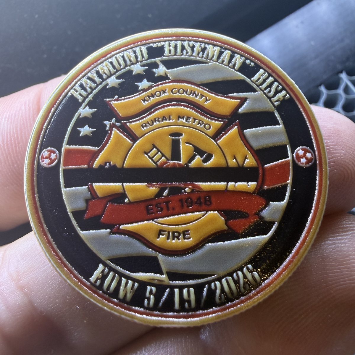 End of Watch side of the Ray Bise memorial coin: a Knox County Rural Metro Fire Maltese cross over an American flag, ringed with Raymond "Biseman" Bise and his End of Watch date
