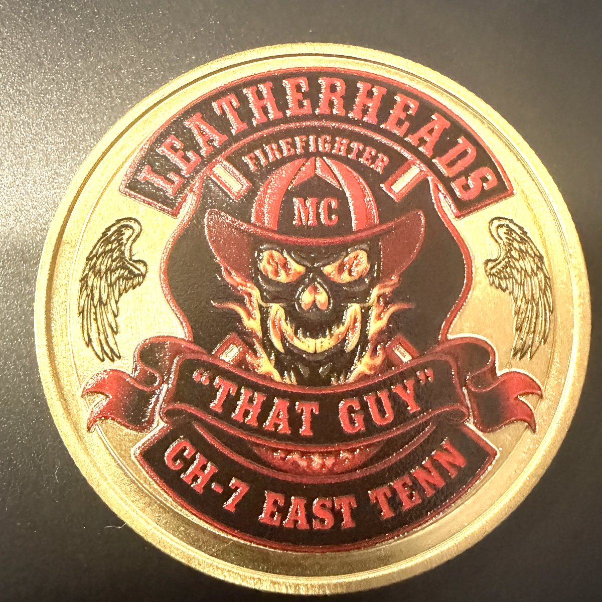 Reverse side of the Ray Bise memorial coin: the Chapter 7 Leatherheads Firefighter Motorcycle Club logo with a flaming skull in a fire helmet