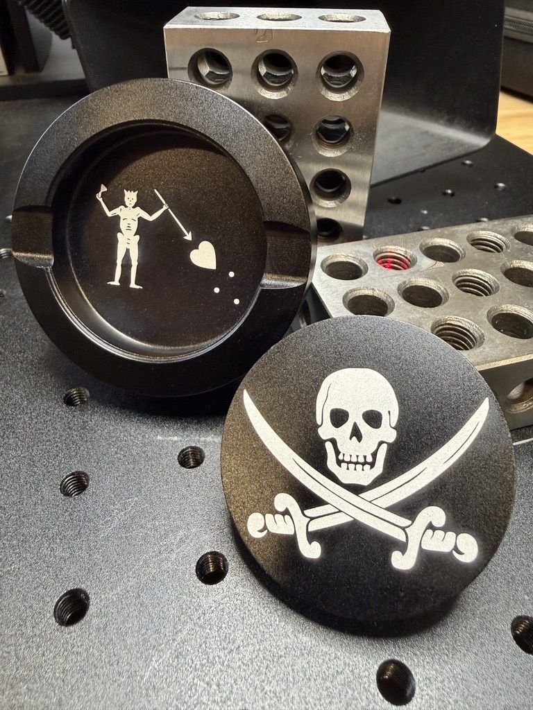Custom laser-engraved coasters with pirate and devil designs — one-off custom work by All Phase Laser