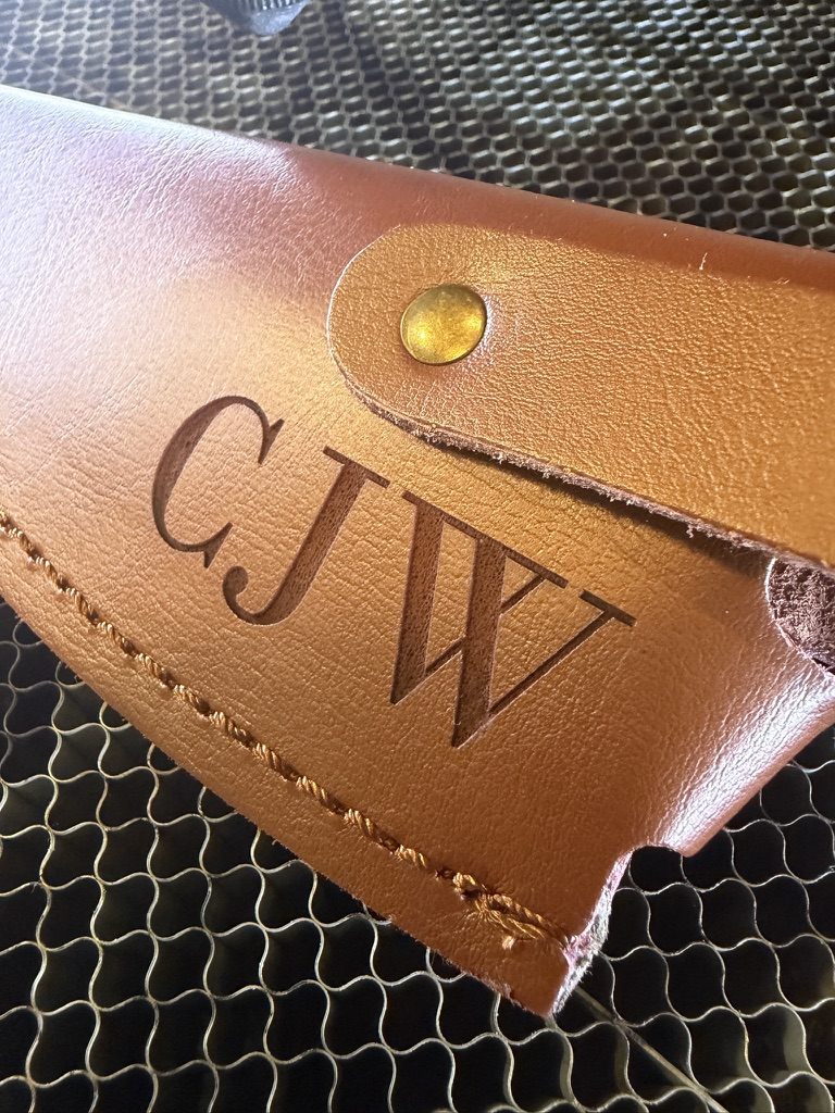 Personalized CJW initials engraved on a tan leather wallet