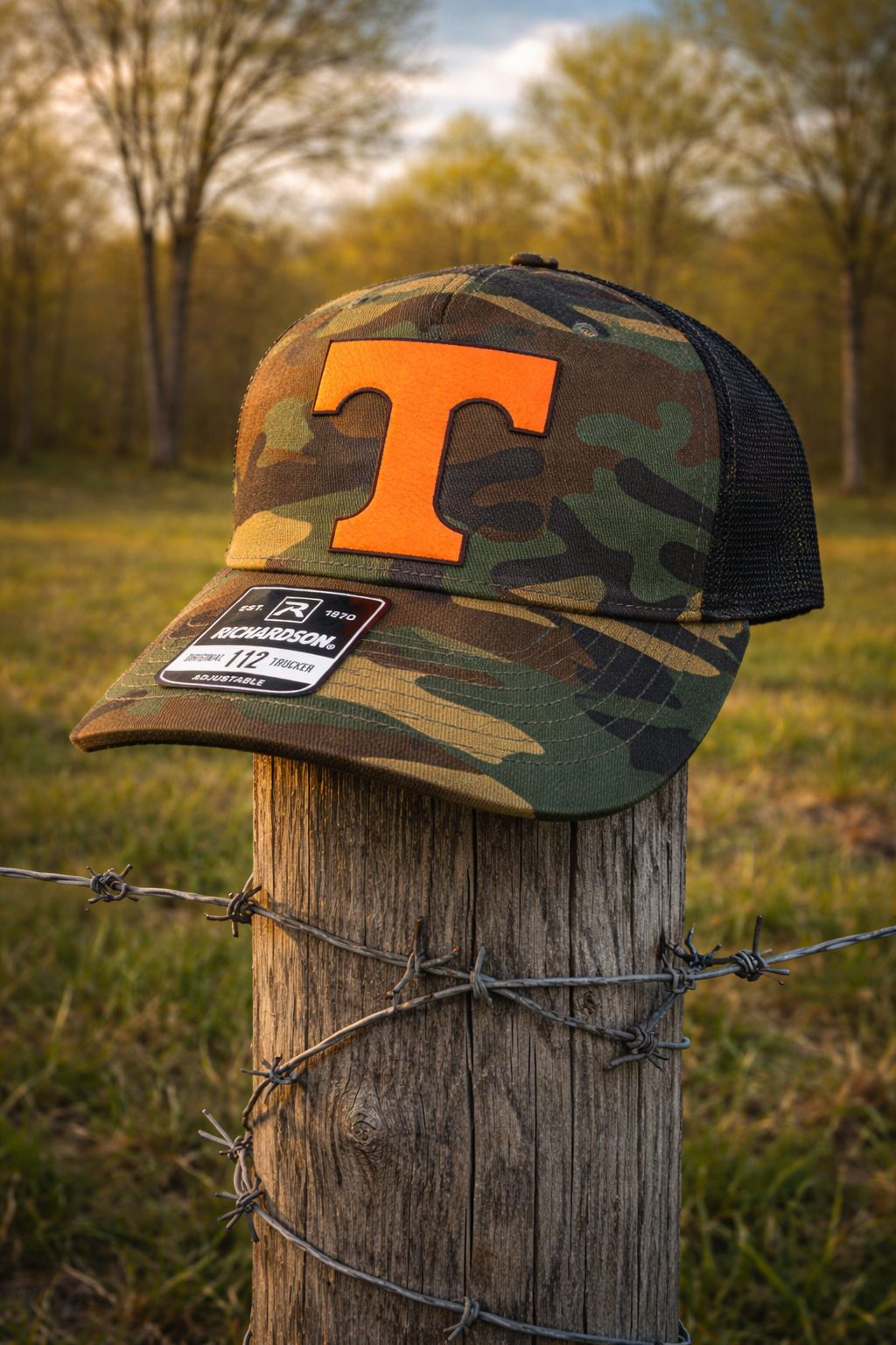 Tennessee orange T patch on a camo trucker hat photographed at golden hour